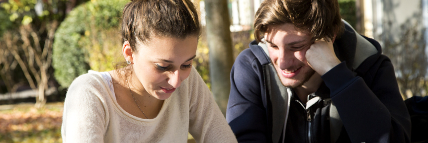 Ragazzo e ragazza seduti vicini a leggere