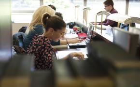 Ragazza che studia in biblioteca