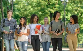 Gruppo di studenti cammina con libri in mano