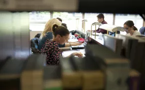 Studentessa studia in biblioteca