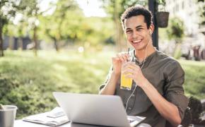 Studente ride e beve mentre studia all'aperto