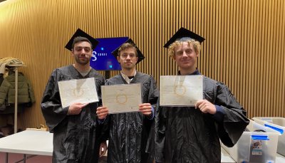 Tre studenti con toga e tocco mostrano il diploma di laurea