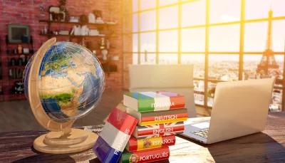 Mappamondo con libri in lingue straniere e notebook aperto