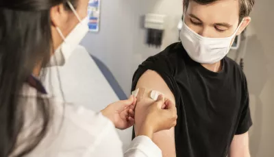 Un operatore sanitario esegue la vaccinazione ad un ragazzo