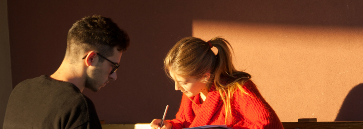 Un ragazzo e una ragazza studiano seduti ad un tavolo