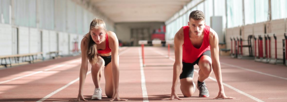 ragazza e ragazzo in partenza sulla pista da corsa